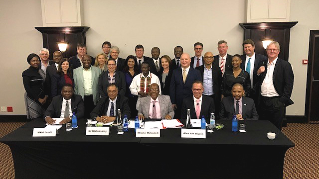 Attorney Mike Elsner (back, second from right) with co-counsel Richard Spoor (far right), South African Minister of Health Aaron Motsoaledi (center seat), Gold Mine Company Officers and Directors and respondents’ lawyers after signing the historic settlement agreement for South African gold workers’ class action today in Johannesburg.