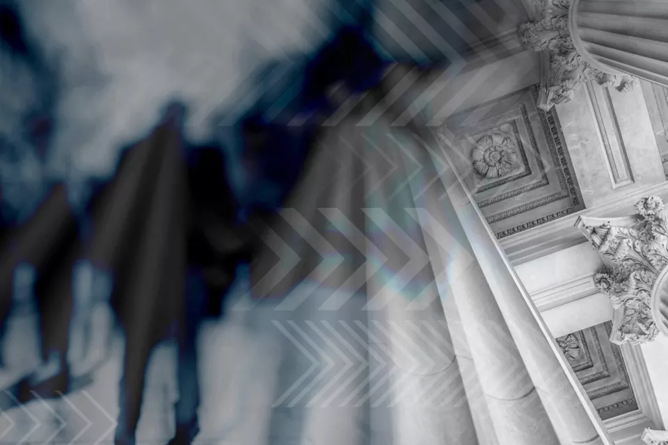 Silhouettes reflected onto a picture of the coffered ceiling of a courthouse, featuring elaborate Roman columns.