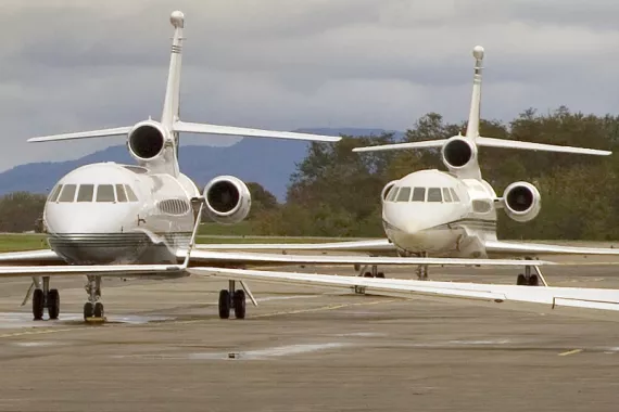 Two midsize planes sit on a tarmac