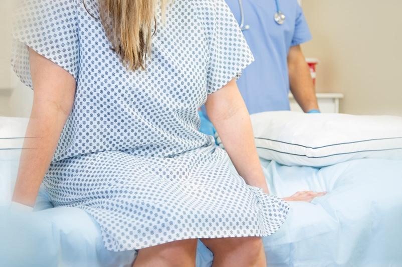 Pile of pills next to woman on hospital bed