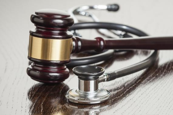 A judge's gavel and a doctor's stethoscope placed side-by-side on a table